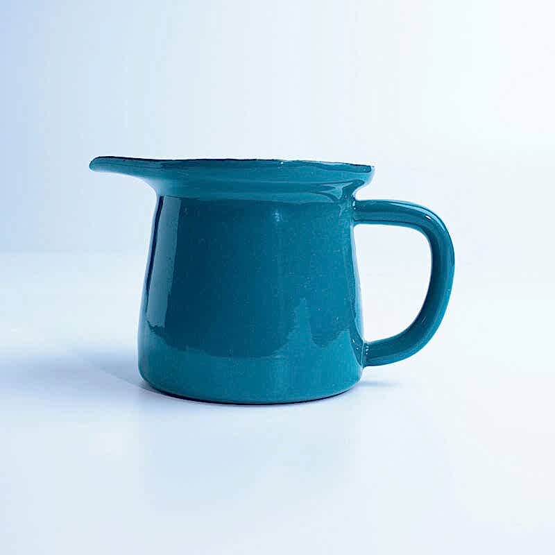 Beyaz zemin üzerinde duran, kulplu ve ağızlı, parlak petrol yeşili emaye sosluk.