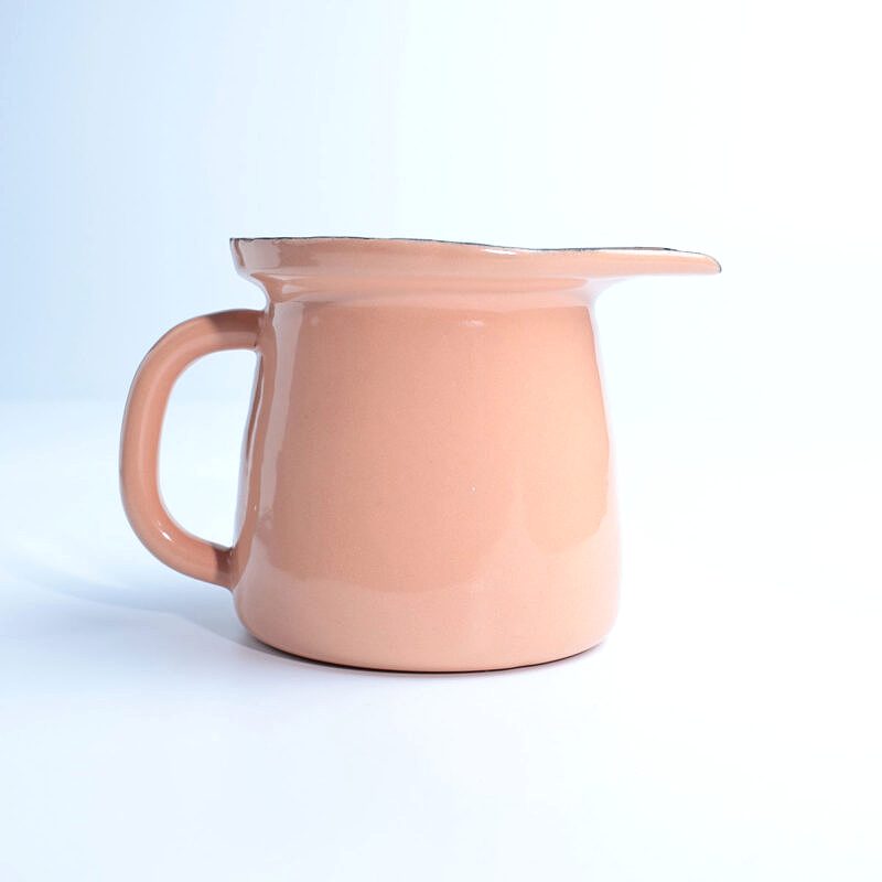 Beyaz zemin üzerinde duran, kulplu ve ağızlı, parlak yavruağzı renkte emaye sosluk.